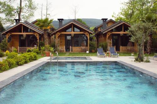 uma casa com piscina em frente a uma casa em Gölevi Resort Sapanca em Sapanca