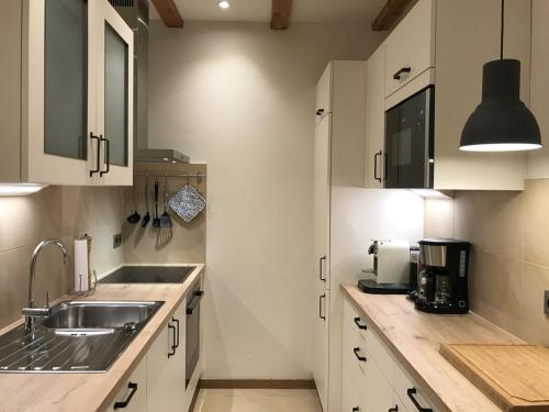 a kitchen with white cabinets and a sink at Haus Bliestal-Blick in Blieskastel