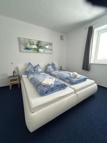 1 cama blanca con almohadas azules en una habitación en Babsi Appartments - leben am Land, en Wels