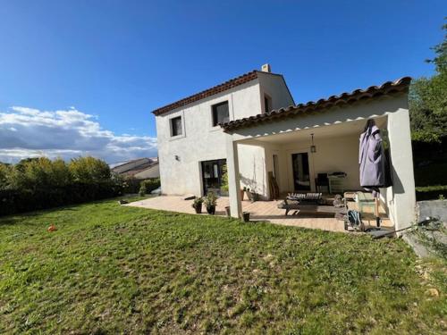 une maison blanche avec une robe accrochée dans la cour dans l'établissement VILLA EYRAGUES-SAINT RÉMY DE PROVENCE spa et accès piscine, à Eyragues