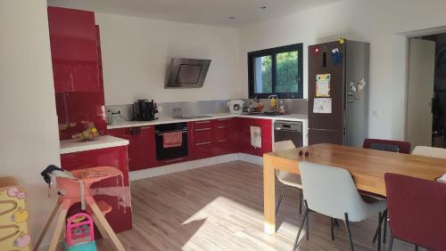 une cuisine avec des placards rouges et une table en bois dans l'établissement VILLA EYRAGUES-SAINT RÉMY DE PROVENCE spa et accès piscine, à Eyragues