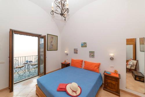 a bedroom with a bed with a hat and a balcony at Casa Stella di mare in Positano