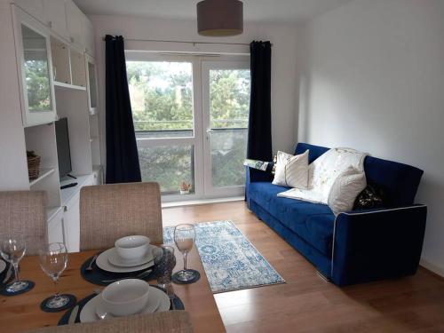 - un salon avec un canapé bleu et une table dans l'établissement NEW 2 Bedroom Flat in Hatfield, à Hatfield