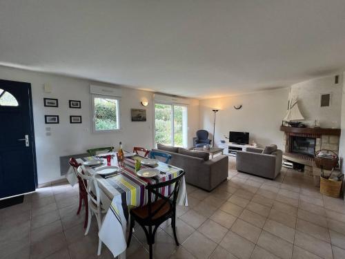 un salon avec une table et un canapé dans l'établissement Maison Quartier de la Fresnaye 8 personnes, à LʼIsle-Saint-Cast