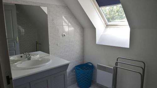 une salle de bain blanche avec un lavabo et une fenêtre dans l'établissement Maison Quartier de la Fresnaye 8 personnes, à LʼIsle-Saint-Cast