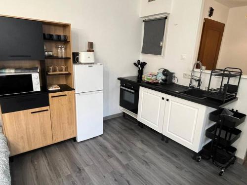 a kitchen with a white refrigerator and wooden cabinets at Suite Familiale - 15 min Disney in Bussy-Saint-Georges