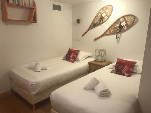 Duas camas individuais num quarto com uma borboleta na parede em Superbe chalet 10 personnes 5 chambres Les Houches em Les Houches