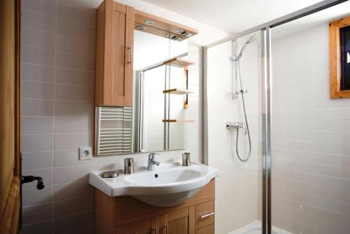 uma casa de banho com um lavatório e um chuveiro com um espelho. em Superbe chalet 10 personnes 5 chambres Les Houches em Les Houches