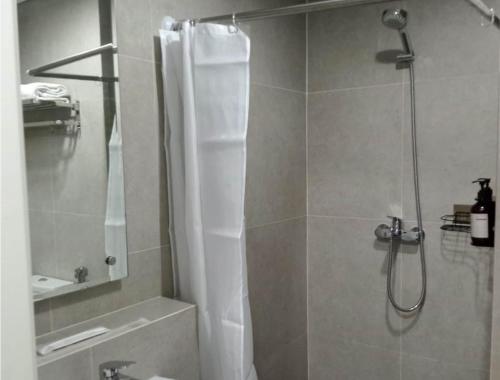a shower with a shower curtain in a bathroom at The Cozy Rooms at The Ayoma Residence, BSD Serpong in Pondok-sentul