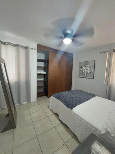 a bedroom with a bed and a ceiling fan at Depto con clima y estacionamiento frente 25 IMSS in Monterrey