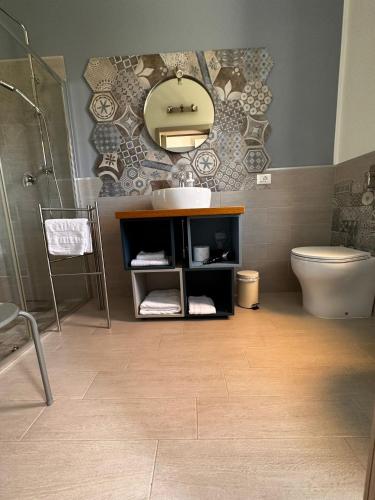 a bathroom with a sink and a toilet and a mirror at Sole di Maggio in Marsala