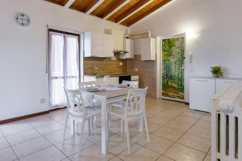 Il comprend une cuisine et une salle à manger avec une table et des chaises blanches. dans l'établissement Il trentanove, à Valeggio sul Mincio