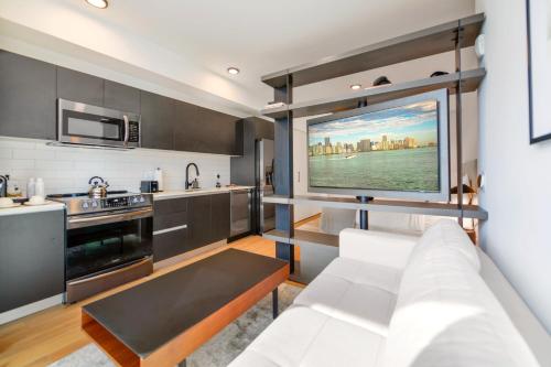 uma sala de estar com um sofá branco e uma cozinha em Incredible High-Floor Studio with Bay Views em Miami