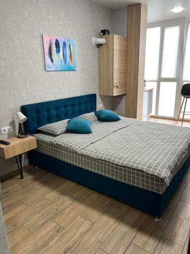 een slaapkamer met een blauw bed met blauwe kussens bij 014-2 Новые Смарт-апартаменты ЖК Олимпия in Kiev