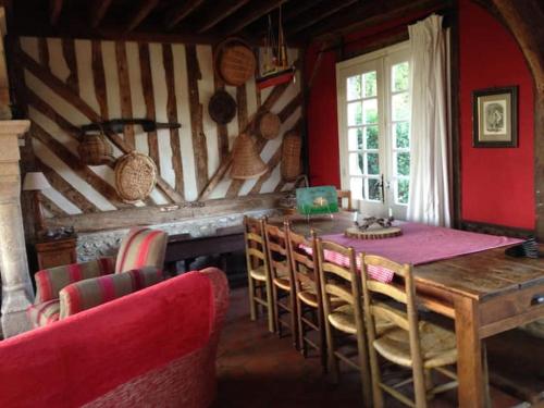 une salle à manger avec une table et des chaises en bois dans l'établissement Rouge Pivoine, Gîte du Manoir de La Porte, à Les Authieux-sur-Calonne