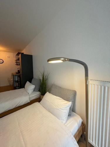una camera con due letti e una lampada di Apartment mit Küchenzeile, stadtnah & kostenlos parken a Passavia