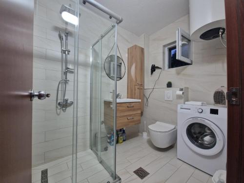 y baño con ducha y lavadora. en Apartman Irvas Kolasin, en Kolašin