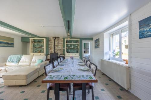 un salon avec une table avec des chaises et un canapé dans l'établissement Izéla, à Cricqueville-en-Bessin