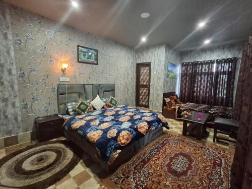a bedroom with a bed and a table in it at D’SHIEKHS RESORT GUREZ in Kanzalwan