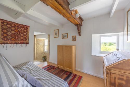 une chambre avec un lit et une fenêtre dans l'établissement Izéla, à Cricqueville-en-Bessin