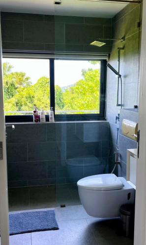 a bathroom with a tub and a toilet and a window at 07 - Luxurious Haven with Mesmerizing Views in Surin Beach