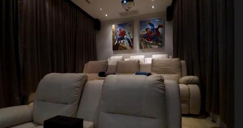 a living room with a white couch and chairs at 07 - Luxurious Haven with Mesmerizing Views in Surin Beach