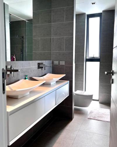 a bathroom with two sinks and a toilet at 07 - Luxurious Haven with Mesmerizing Views in Surin Beach