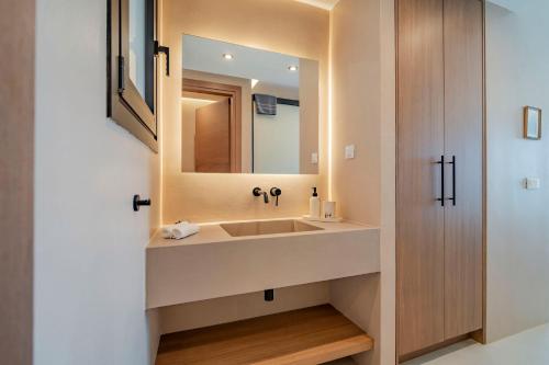 a bathroom with a sink and a mirror at Ocean Rythm Elounda Suite in Elounda