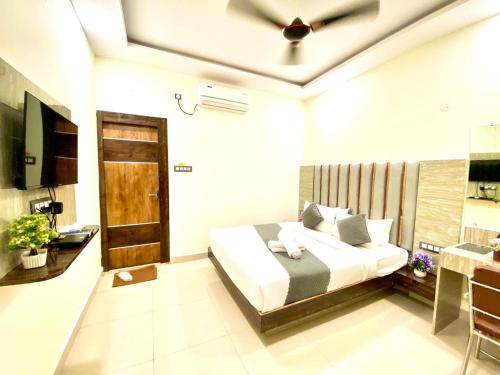 a bedroom with a bed and a television in it at Hotel Sky International- Airport Zone Hyderabad in Shamshabad