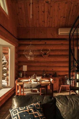 a living room with a table in a wooden room at Le Petit Domaine Caché - Lac-Simon in Lac-Simon