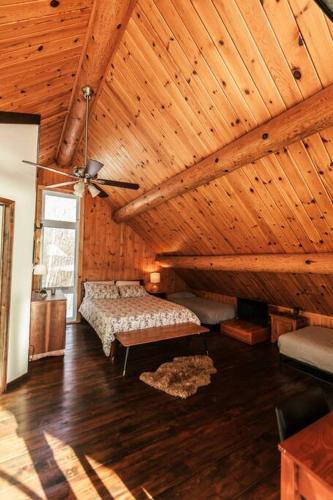 a bedroom with a bed and a wooden ceiling at Le Petit Domaine Caché - Lac-Simon in Lac-Simon