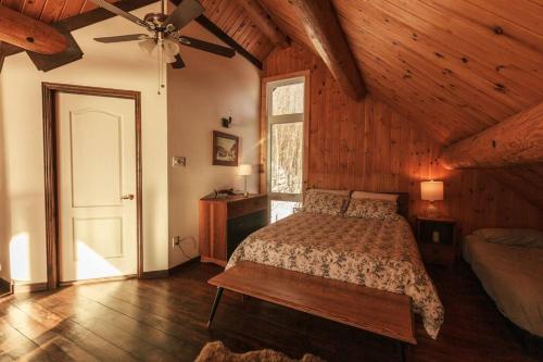 1 dormitorio con 1 cama y ventilador de techo en Le Petit Domaine Caché - Lac-Simon, en Lac-Simon
