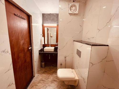 y baño con aseo y lavamanos. en Shrvan Guest house, en Bhavnagar