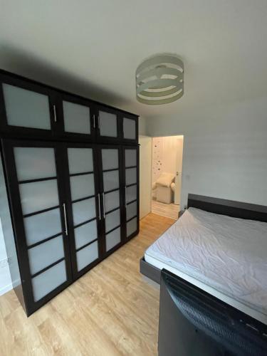 - une chambre avec un lit et une porte en verre dans l'établissement appartement 6 pers à 1km du village olympique, à Saint-Ouen