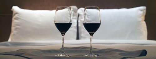 twee glazen rode wijn zittend op een bed bij Aurora appartamento, intero appartamento di 105 mq in Terni