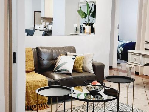 a living room with a couch and two tables at Lemon tree in Pretoria