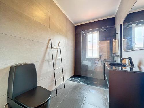 a bathroom with a chair next to a sink at Moradia Uriel in Santa Cruz