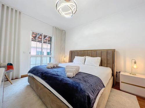 1 dormitorio con 1 cama grande con manta azul en Moradia Uriel en Santa Cruz