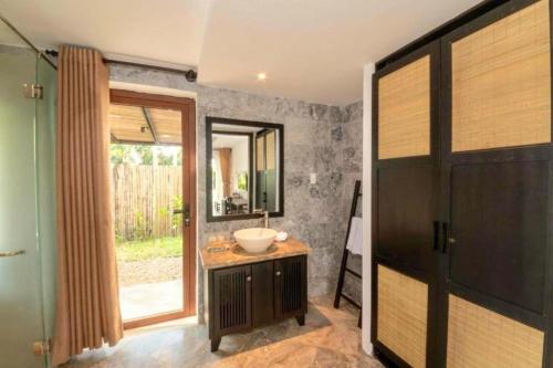 ein Bad mit einem Waschbecken und einem Spiegel in der Unterkunft En Retreat Villa Hoi An in Hiếu Nhơn