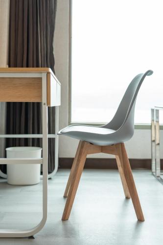 a white chair sitting next to a wooden table at 觀海樓海景大飯店 Hotel Cloud Riverside in Tamsui