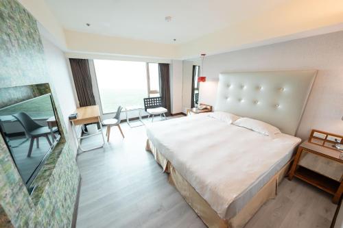a hotel room with a bed and a table and chairs at 觀海樓海景大飯店 Hotel Cloud Riverside in Tamsui