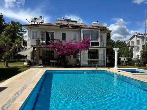 a house with a swimming pool in front of a house at Suit Fiona in Fethiye