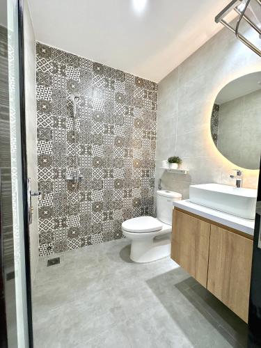 a bathroom with a toilet and a sink and a mirror at Moon Homestay in Thôn Kim Long (1)