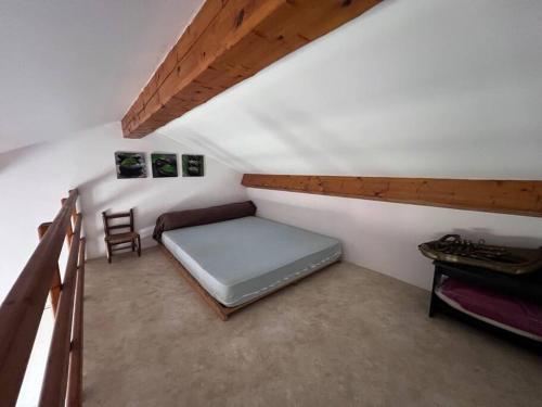 une chambre avec un lit et une chaise dans un grenier dans l'établissement St Raphaël tout à pieds, à Saint-Raphaël