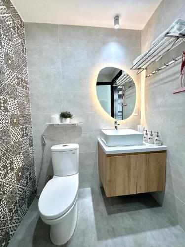 a bathroom with a toilet and a sink and a mirror at Moon Homestay in Thôn Kim Long (1)