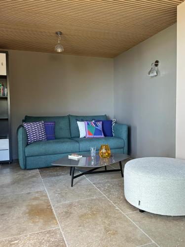a living room with a blue couch and a coffee table at Villa Libecciu in Sainte-Lucie de Porto-Vecchio