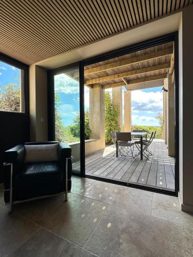 a living room with a couch and a patio at Villa Libecciu in Sainte-Lucie de Porto-Vecchio