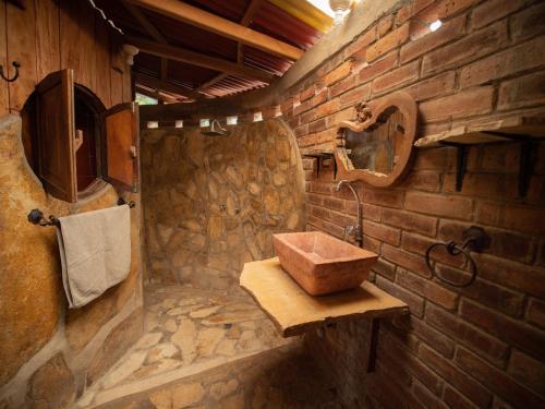 baño con lavabo de madera en una pared de ladrillo en 1 bedroom cabin, 3 blocks from beach and center of San Juan en San Juan del Sur