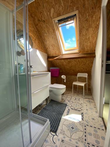 a bathroom with a toilet and a glass shower at Simple et sympa in Vibeuf