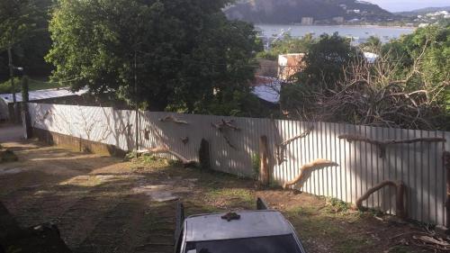 a white fence with a car parked next to it at 1 bedroom cabin, 3 blocks from beach and center of San Juan in San Juan del Sur
